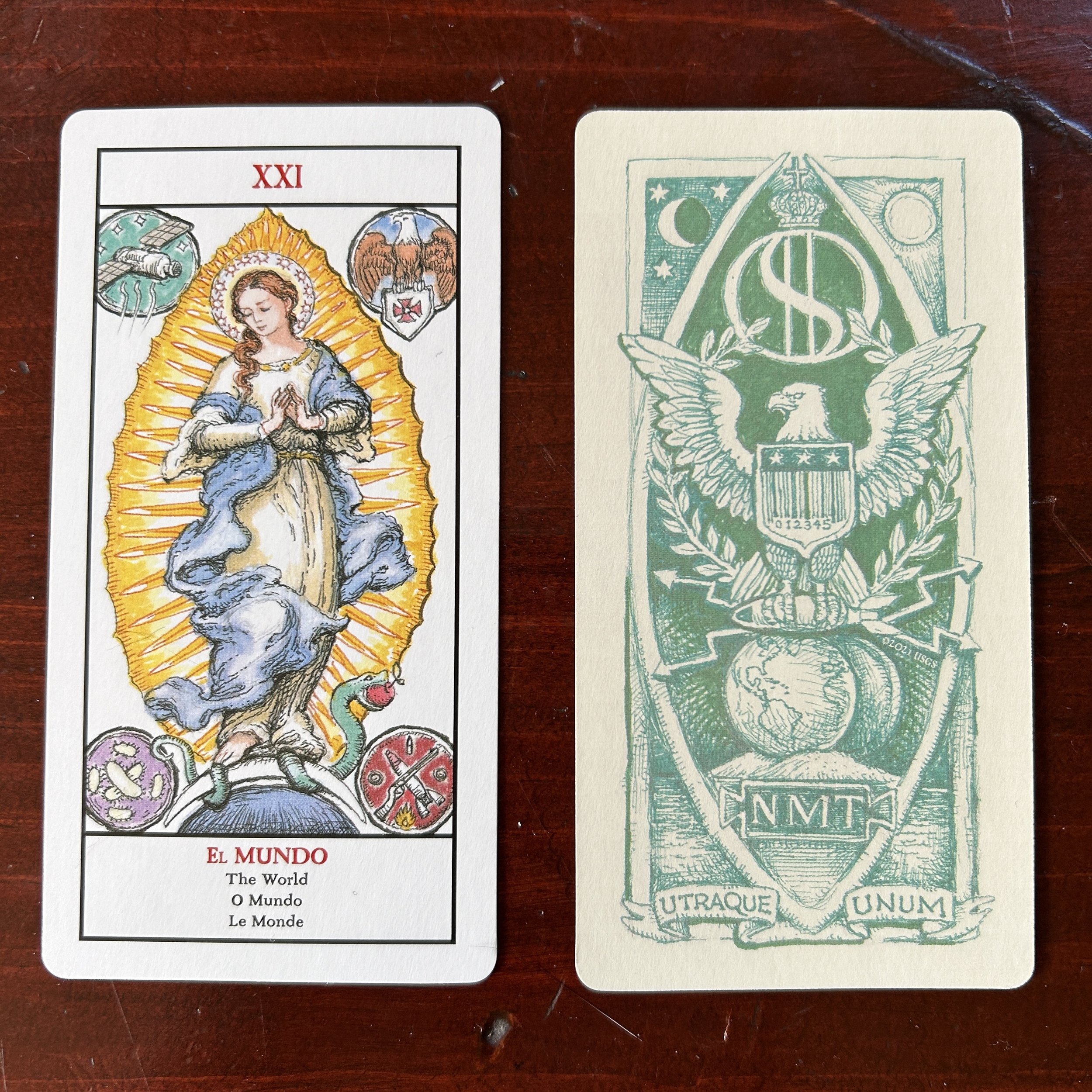 a tarot card on a wood background with shells, rocks, and other natural objects next to it