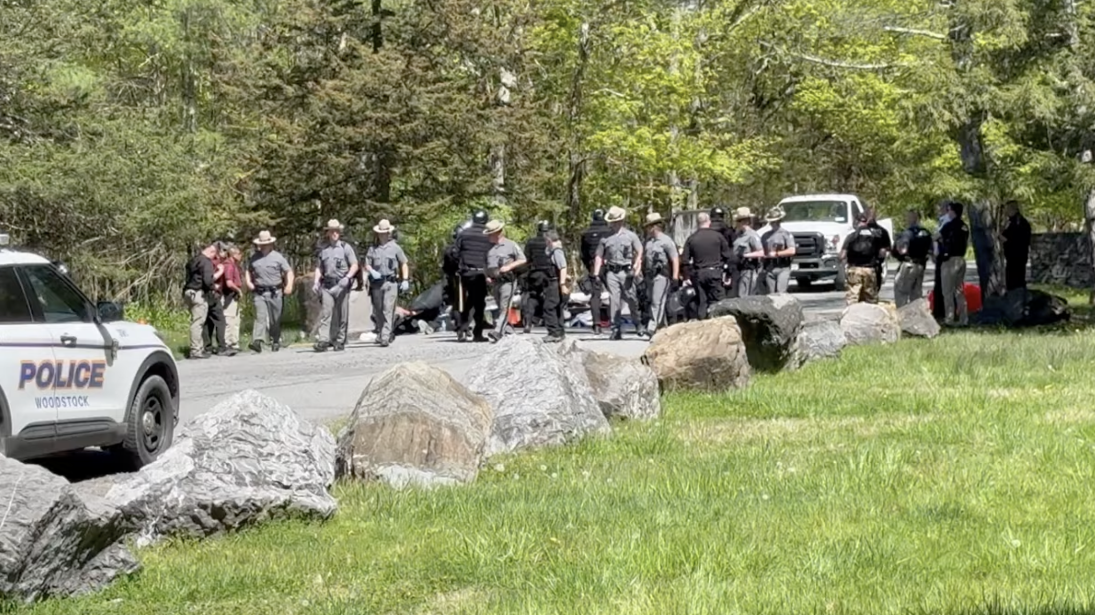 men in state trooper uniforms walk away from a line of protesters