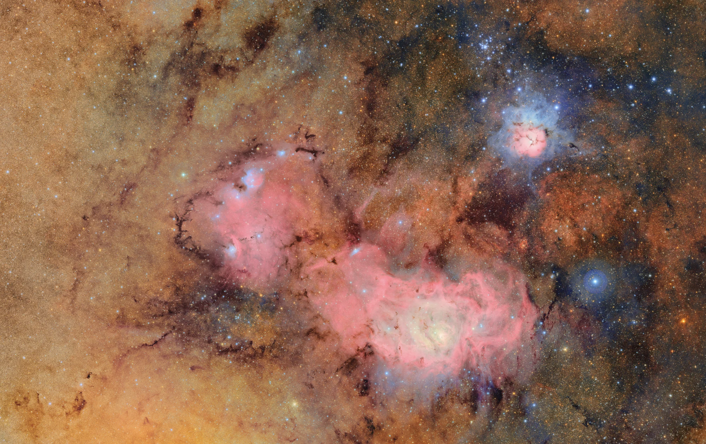    a pink and gold nebula in the center of an image of deep space and stars beyond counting   