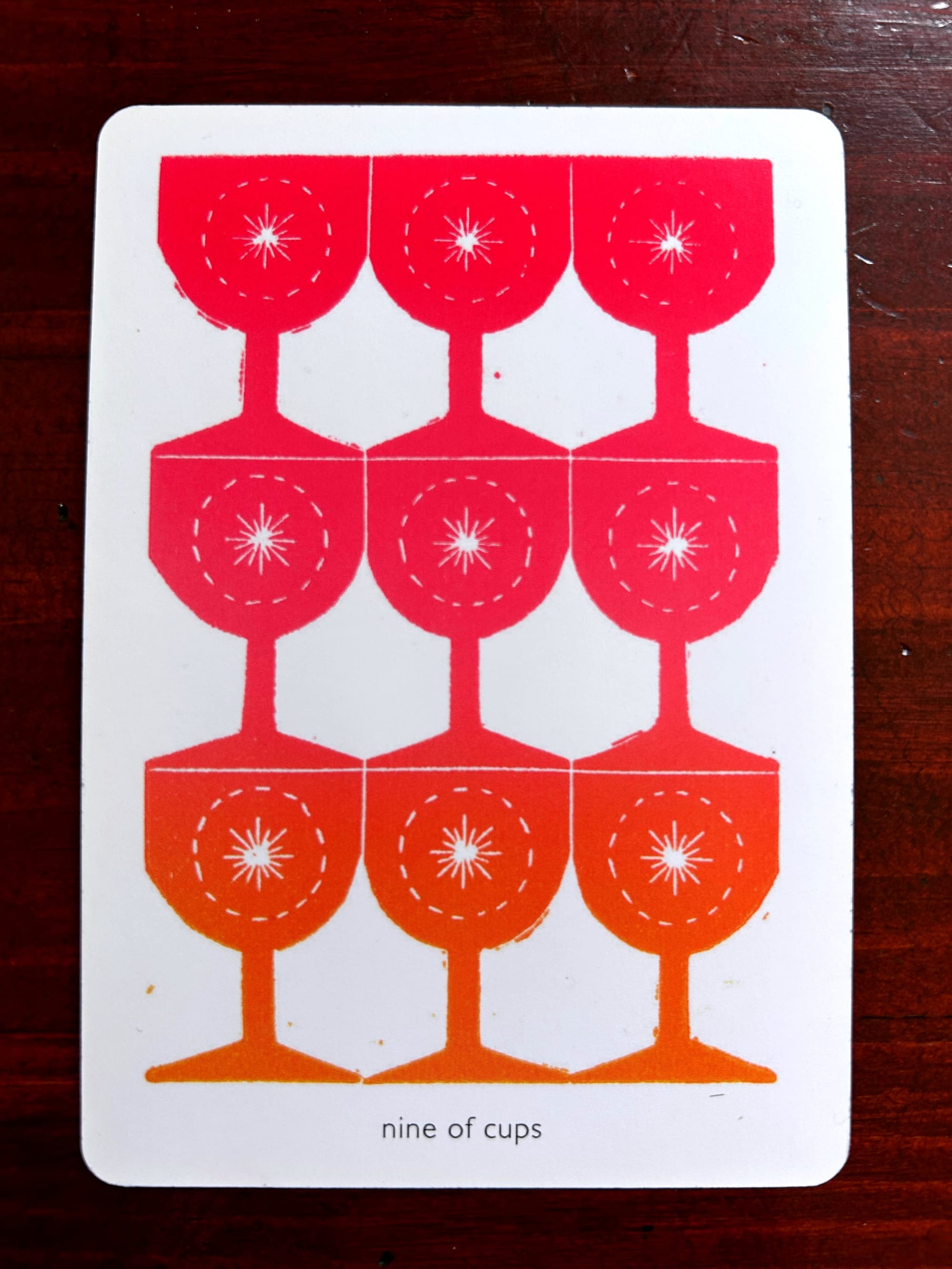 linocut print of 9 pink-orange stacked goblets against a white ground