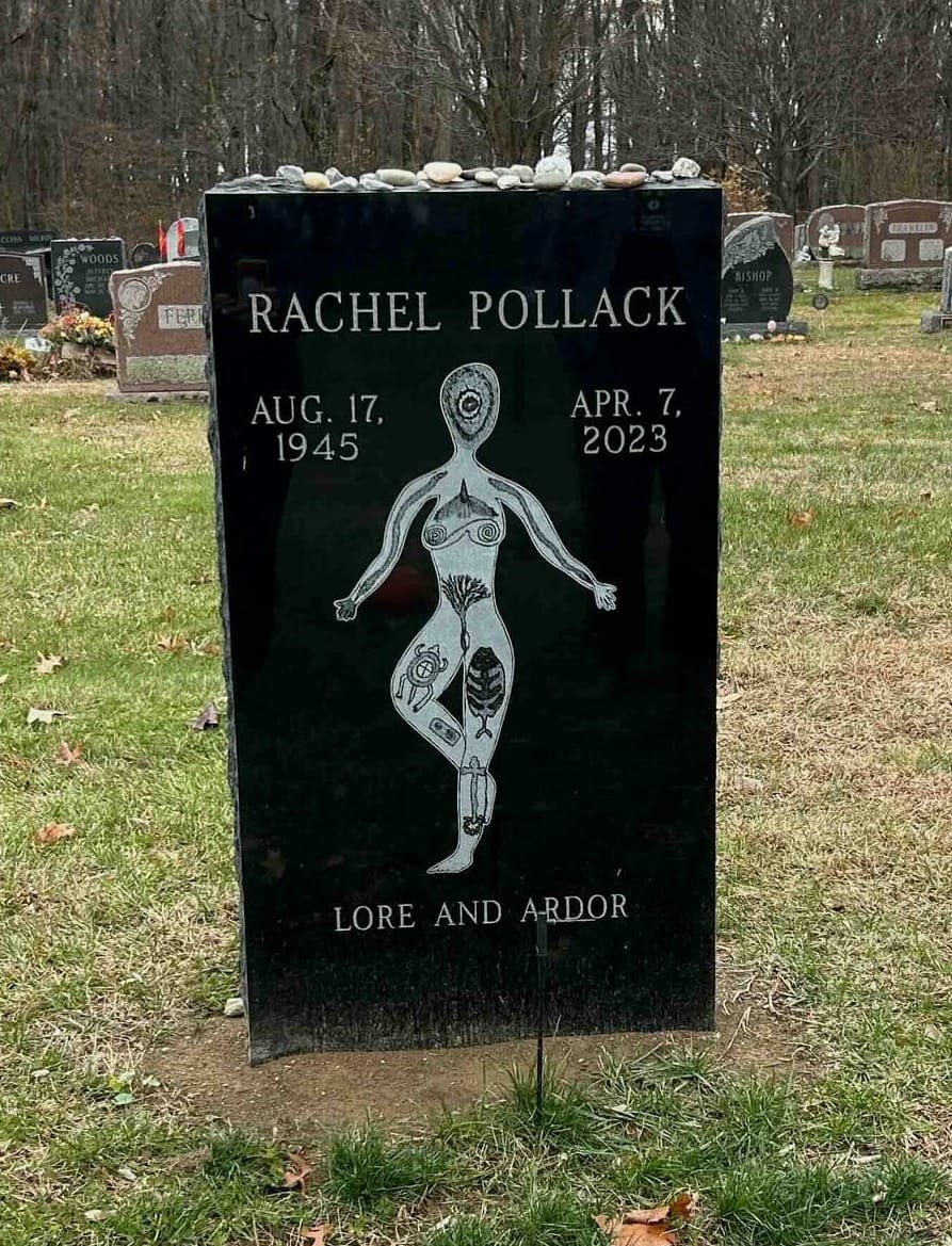 a black rectangular grave marker with an etched image of a figure standing on one leg with symbols throughout their body and the words Lore and Ardor