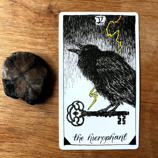 hierophant tarot card showing a black cawing crow with an antique key in its talons a yellow bolt of lightning is striking the key