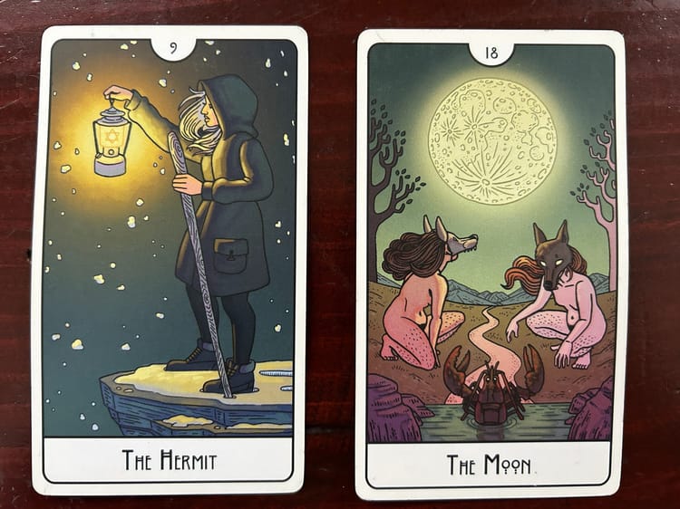 two tarot cards on a wood background