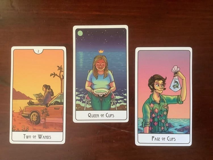 3 tarot cards against a dark wood background