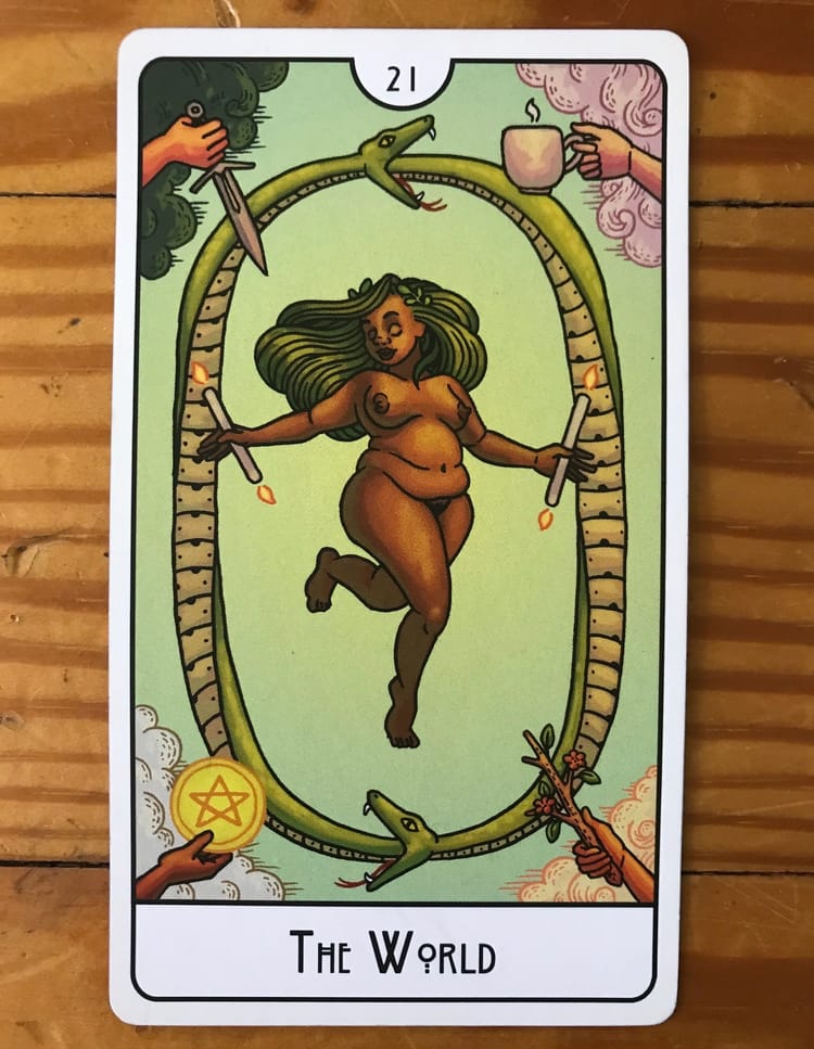 a tarot card showing a fat, brown femme body holding a candle lit at both ends in each hand, floating inside a ring of two snakes, against a wood background