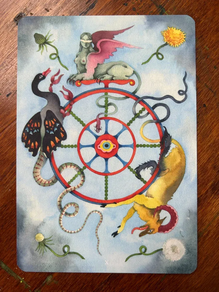 a surreal watercolor painting depicting three colorful chimeras along the edge of a colorful wheel with an eye at the hub; a dandelion in different stages of growth at each corner, all agains
