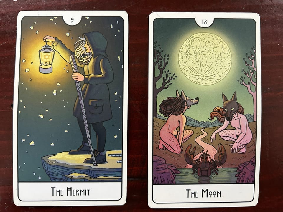 two tarot cards on a wood background