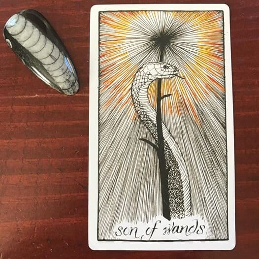 an upright snake wraps its head around a black wand whose tip is radiating black and orange lines