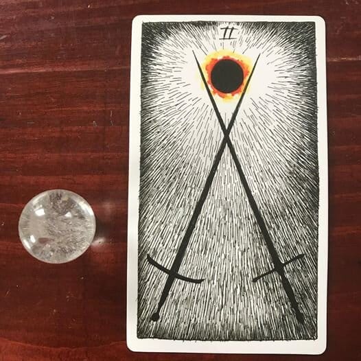 two black crossed swords with an eclipsed sun in the V where the sword tips cross